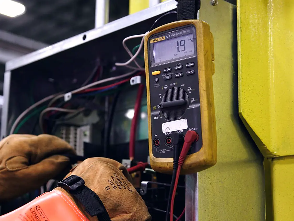 Electrician testing an electrical box with a multimeter