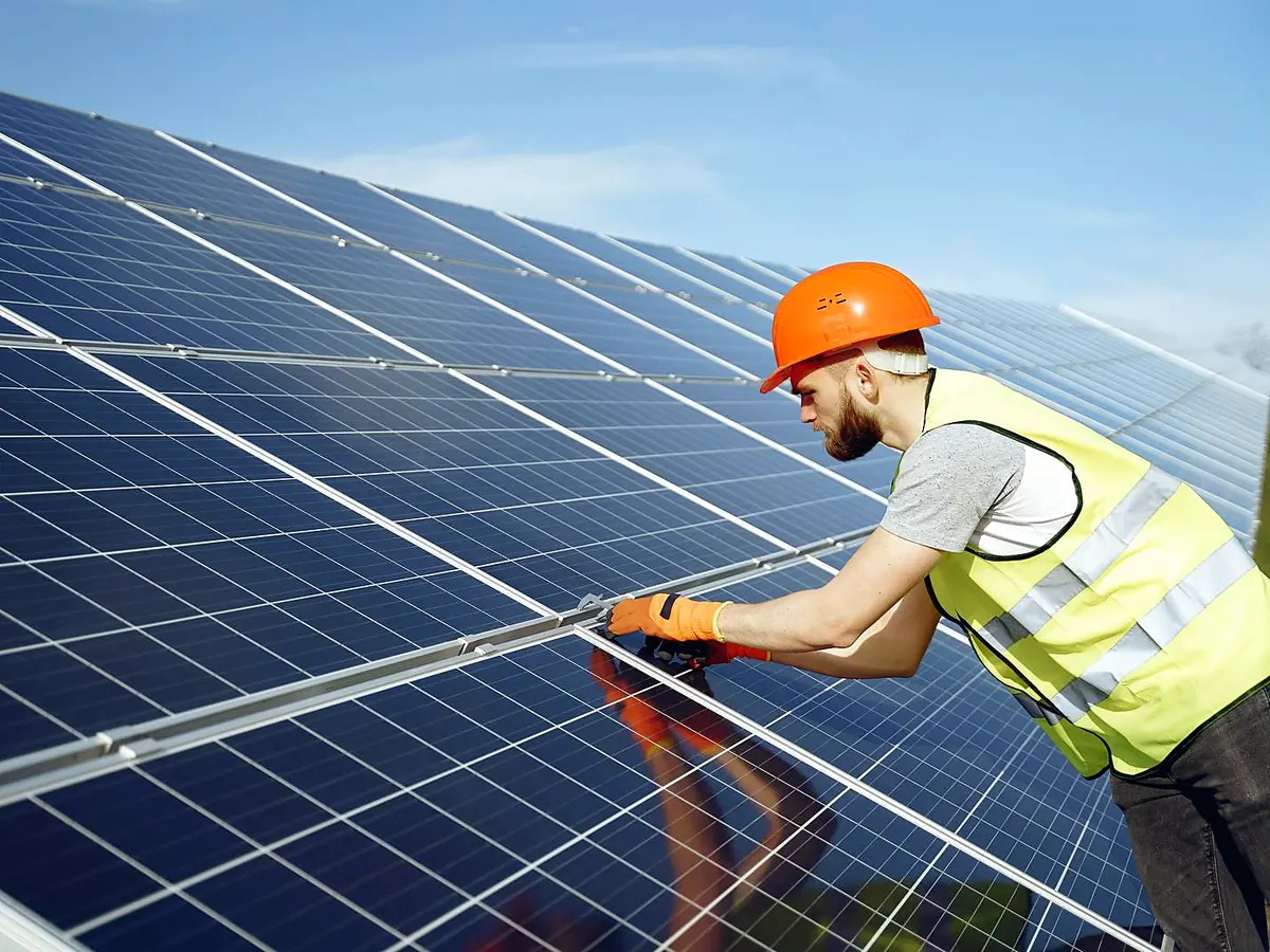 Technician inspecting a solar panel array